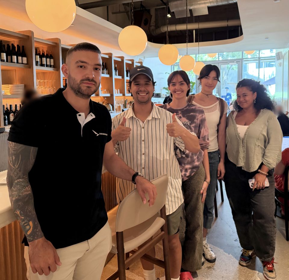 A Don Manager instructor with four class attendees, smiling, after an on-site class in a restaurant